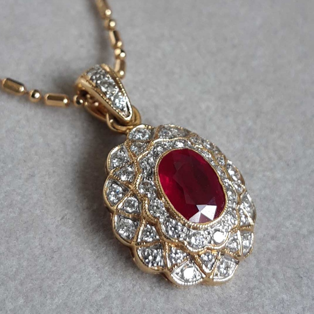 Pendentif rubis et diamants – or 18 K, Un joyau rare dont l’éclat profond raconte la puissance des sentiments éternels. Autour d’un rubis « sang de pigeon » aux reflets ardents, les diamants composent une auréole lumineuse qui exalte sa beauté. Symbole de passion et de force vitale, ce pendentif célèbre les liens qui traversent les générations et perpétuent l’amour dans sa forme la plus pure.