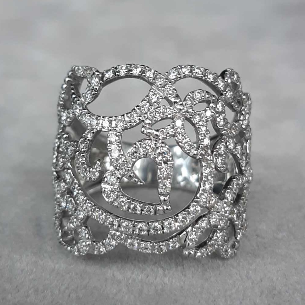 Bague dentelle en or blanc 18K et diamants — poésie ajourée de lumière— Sculptée dans une fine dentelle d’or blanc, cette création se distingue par l’élégance de ses ajours et l’éclat délicat de son pavage de diamants naturels. Son dessin aérien, aux courbes organiques et aux motifs inspirés de la nature, capte la lumière sous tous les angles et la fait danser avec grâce. Symbole d’élégance intemporelle et de virtuosité artisanale, cette bague conjugue légèreté, raffinement et éclat pour sublimer la main d’un éclat poétique.